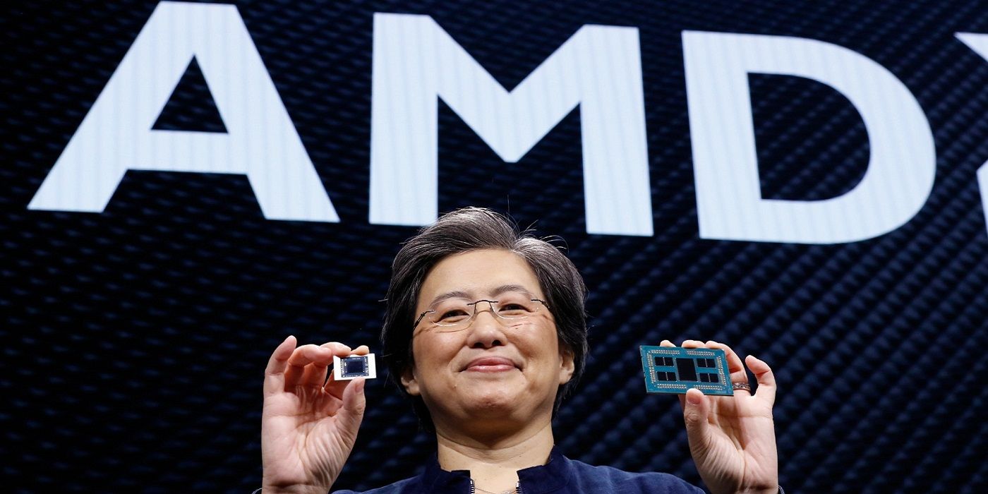 AMD CEO Lisa Su holding chips in front of the company logo.