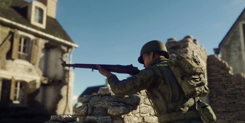 Soldier uses a stone wall as cover from enemy fire