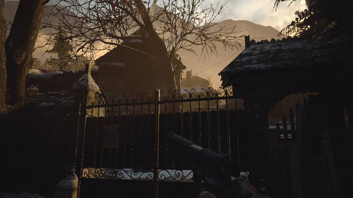 resident evil village house set behind iron gate at daybreak