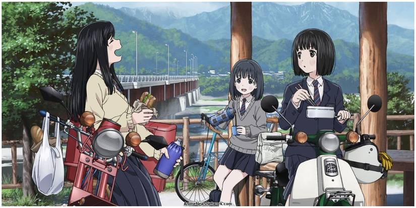 Three women chatting around motorcyles.