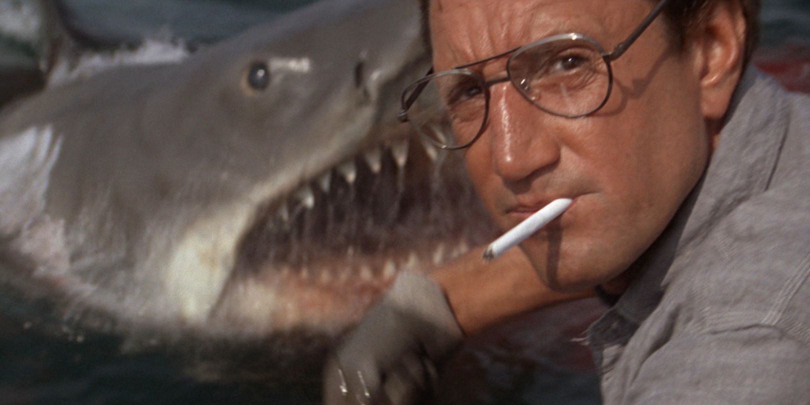 The shark breaches the water behind Brody in Jaws