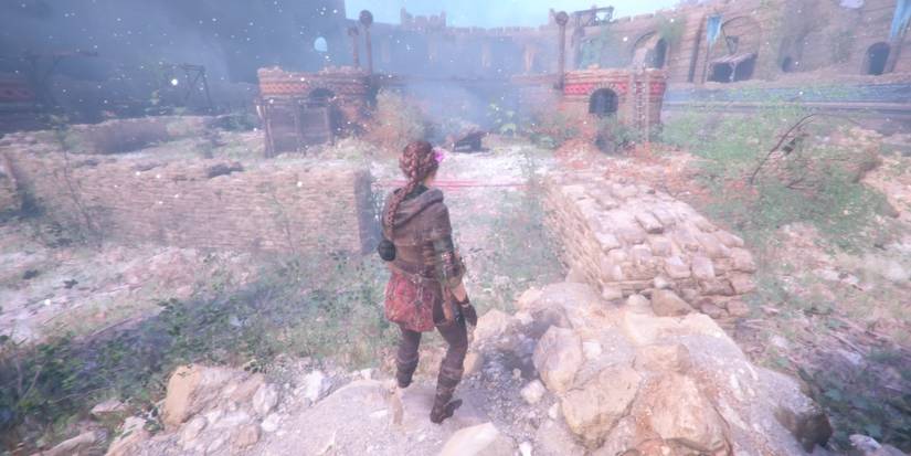 A cart between the red and yellow section of the inner courtyard in Chateau d'Ombrage in A Plague Tale: Innocence.