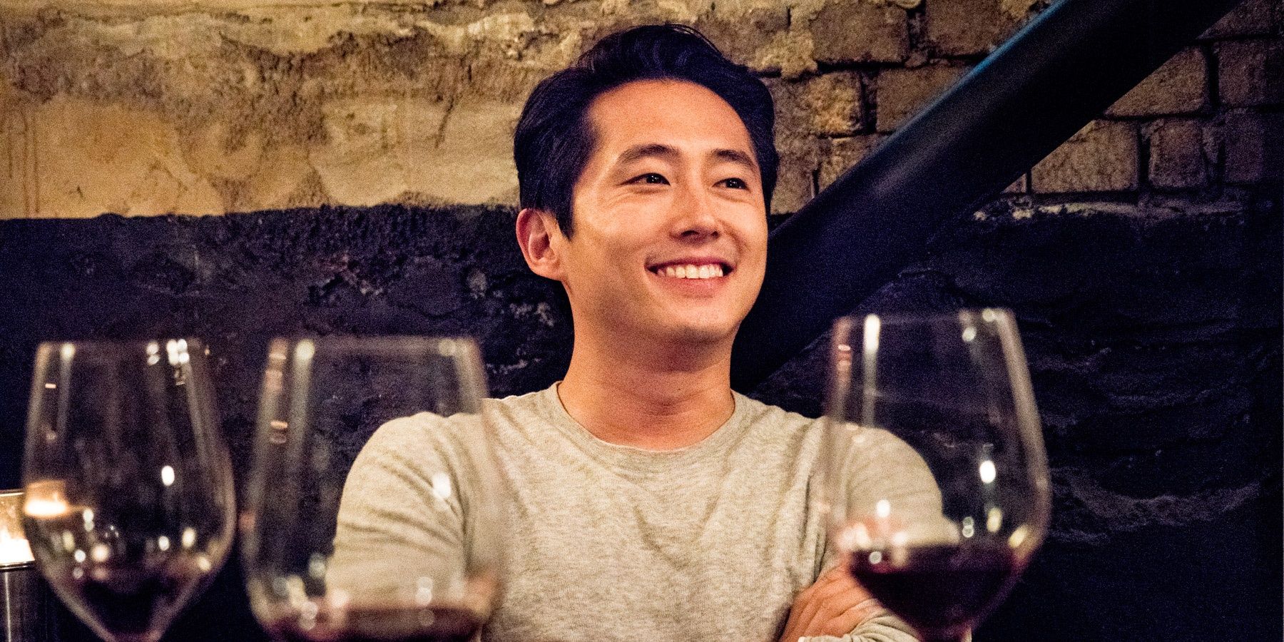 Steven Yeun smiling at table in Burning