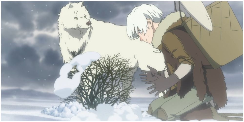 A boy and a wolf examining a bush in the snow.