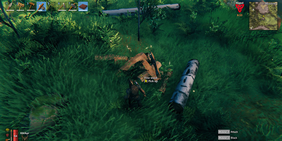 player gathering wood from a felled tree.