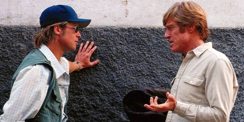 Brad Pitt and Robert Redford talking against wall in Spy Games