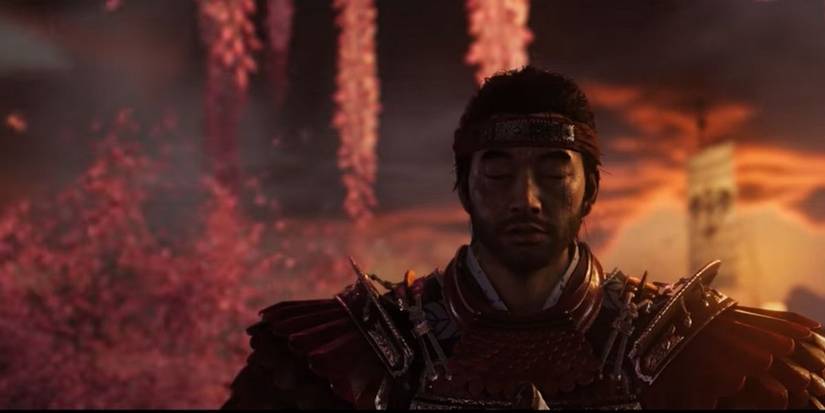 Ghost of Tsushima Jin reflecting as cherry blossom petals swirl behind him