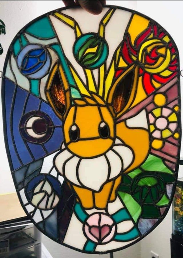 Pokemon Eevee stained glass showing evolution methods
