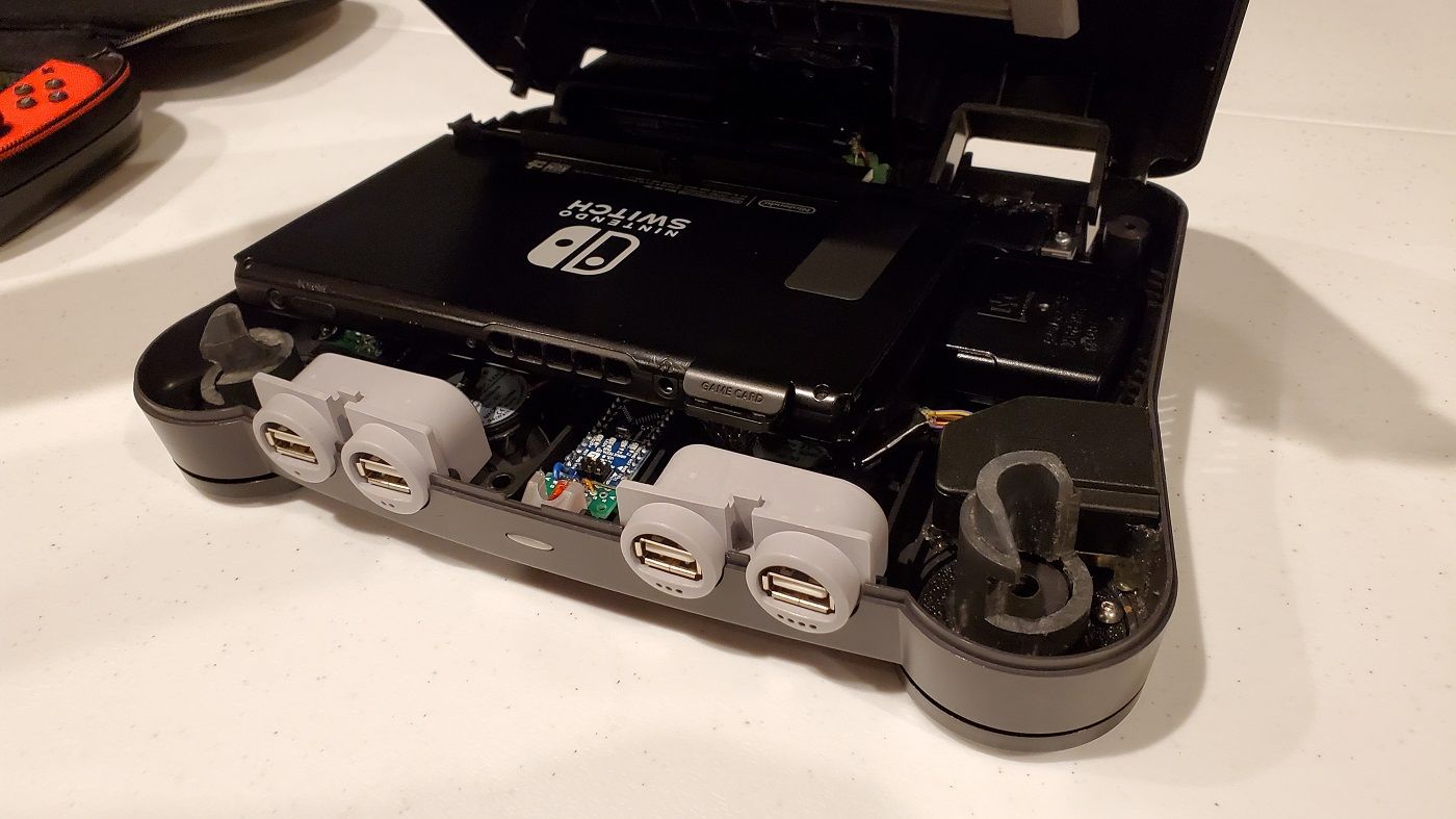 A photo of an open Nintendo 64 console with a Switch inside it.