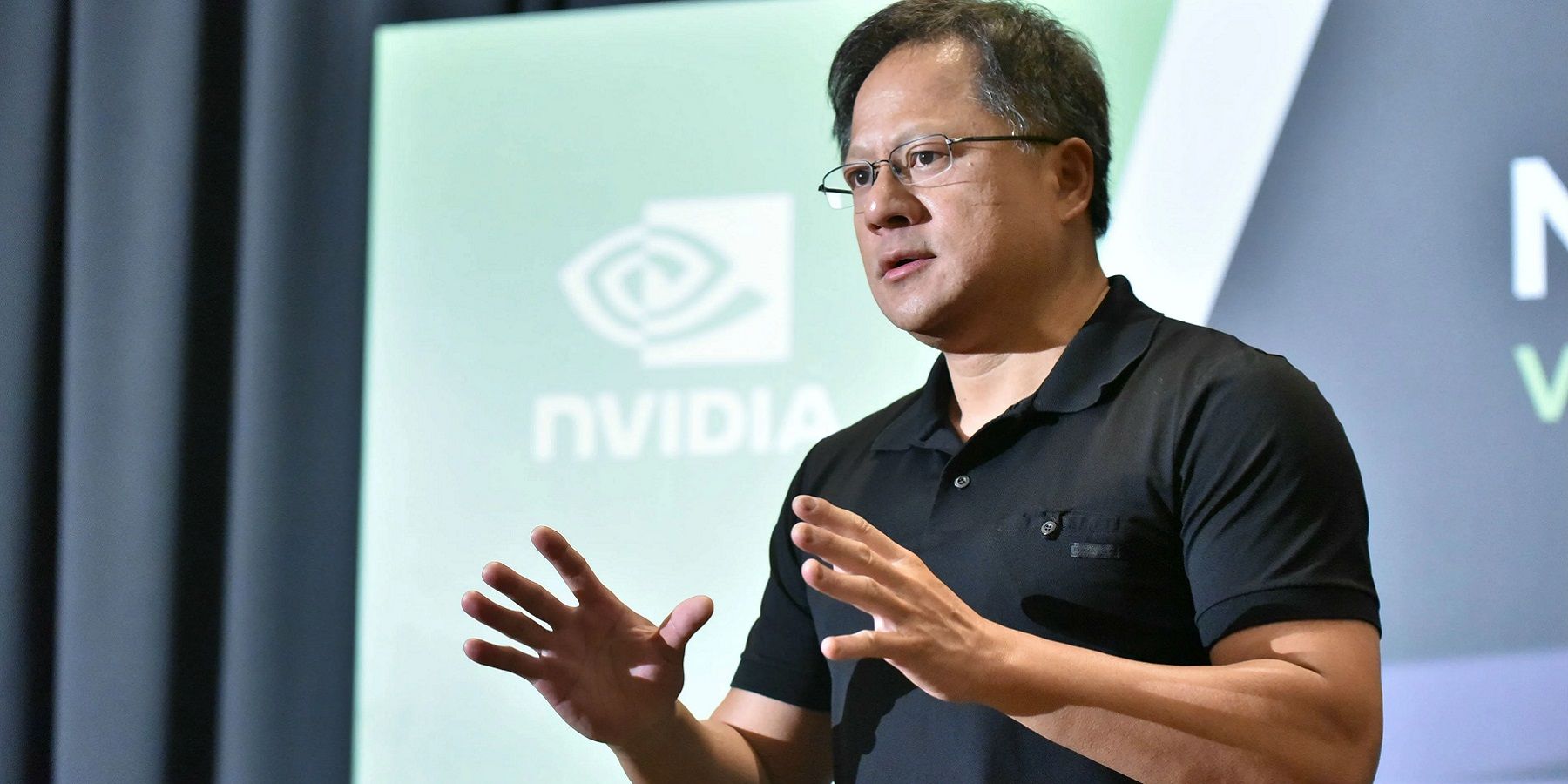 Photo showing Nvidia CEO, Jensen Huang, speaking at a conference.
