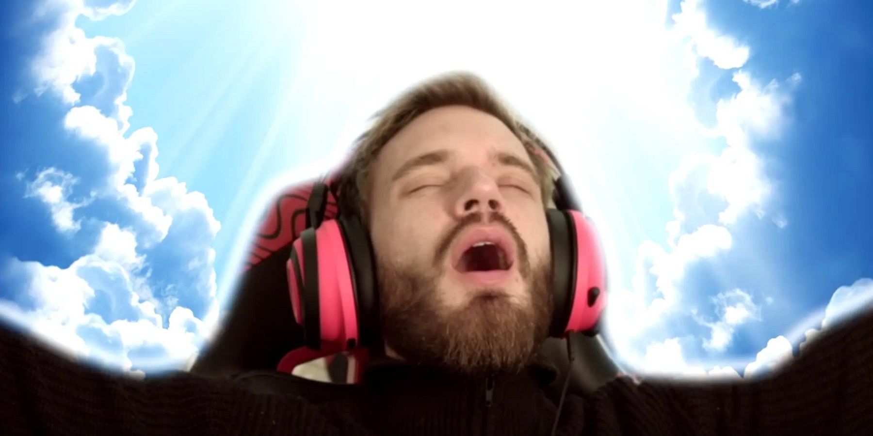 A photo of PewDiePie on a sky background looking up towads the heavens.