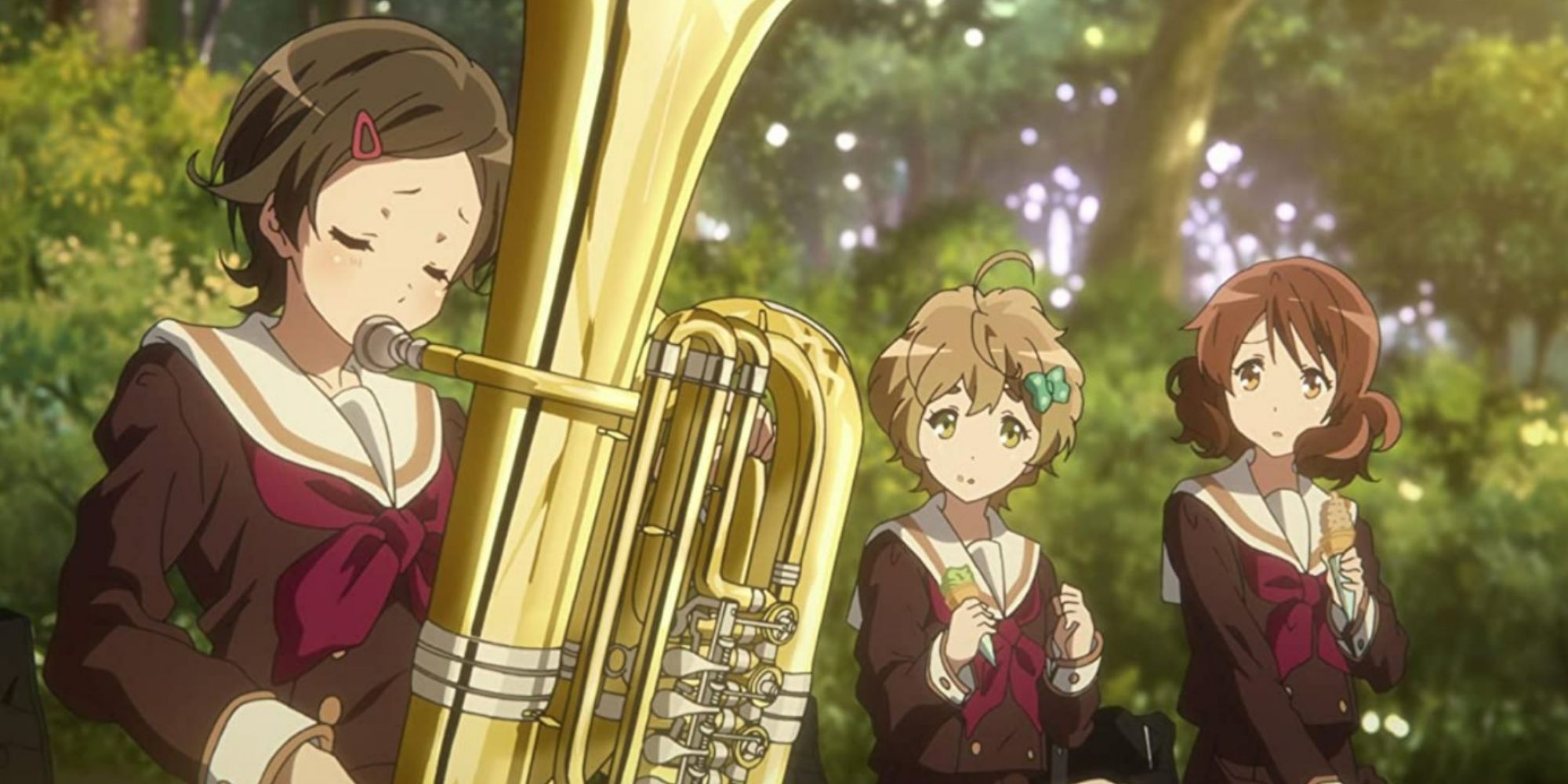 Girl playing instrument as two friends look on in Hibike! Euphonium anime