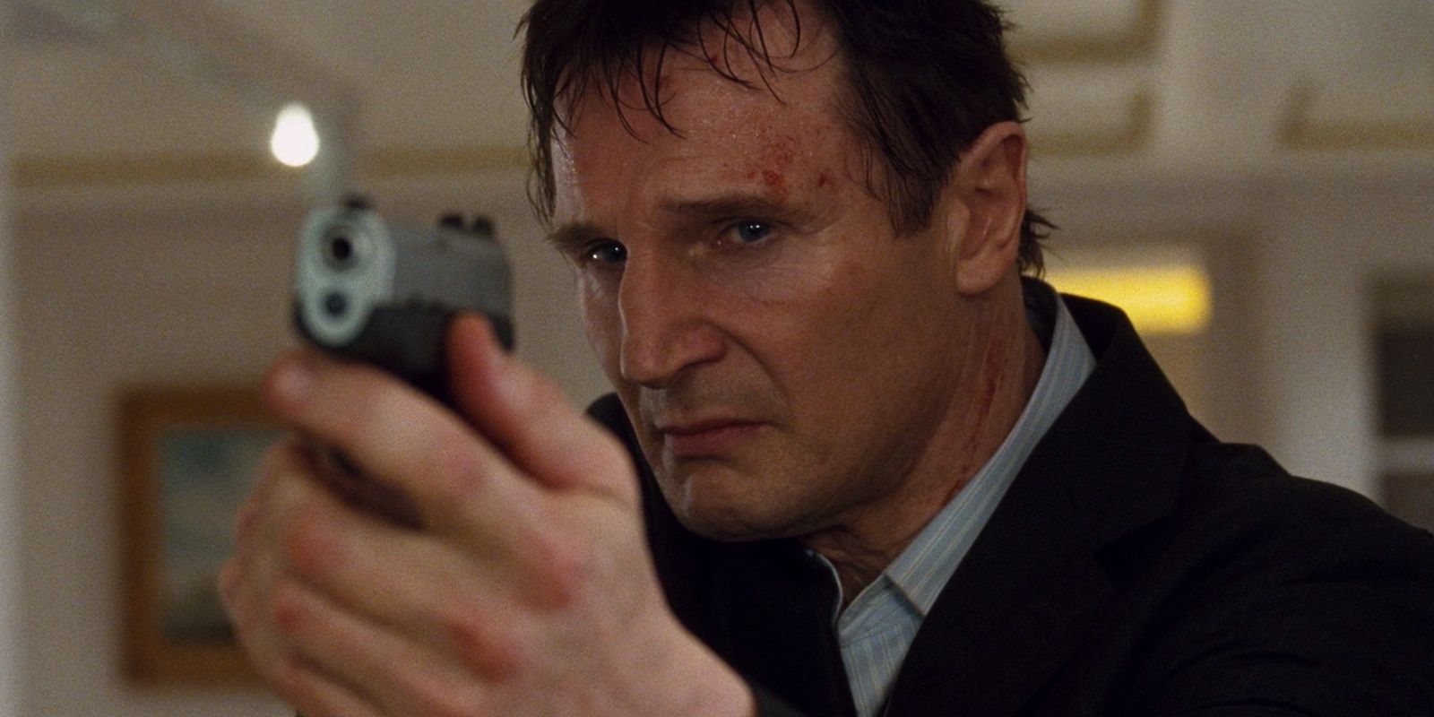 Liam Neeson holding a handgun in Taken