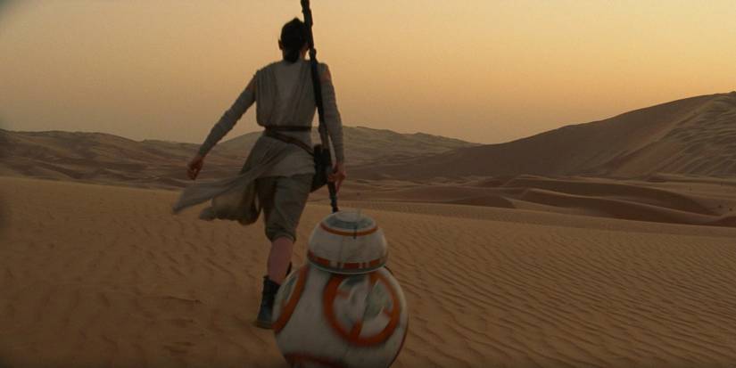 Rey walking across the Jakku desert with BB-8 in The Force Awakens