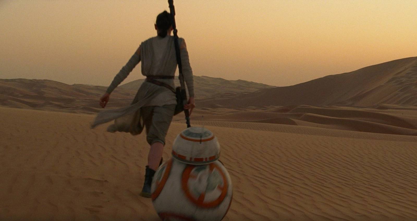 Rey walking across the Jakku desert with BB-8 in The Force Awakens
