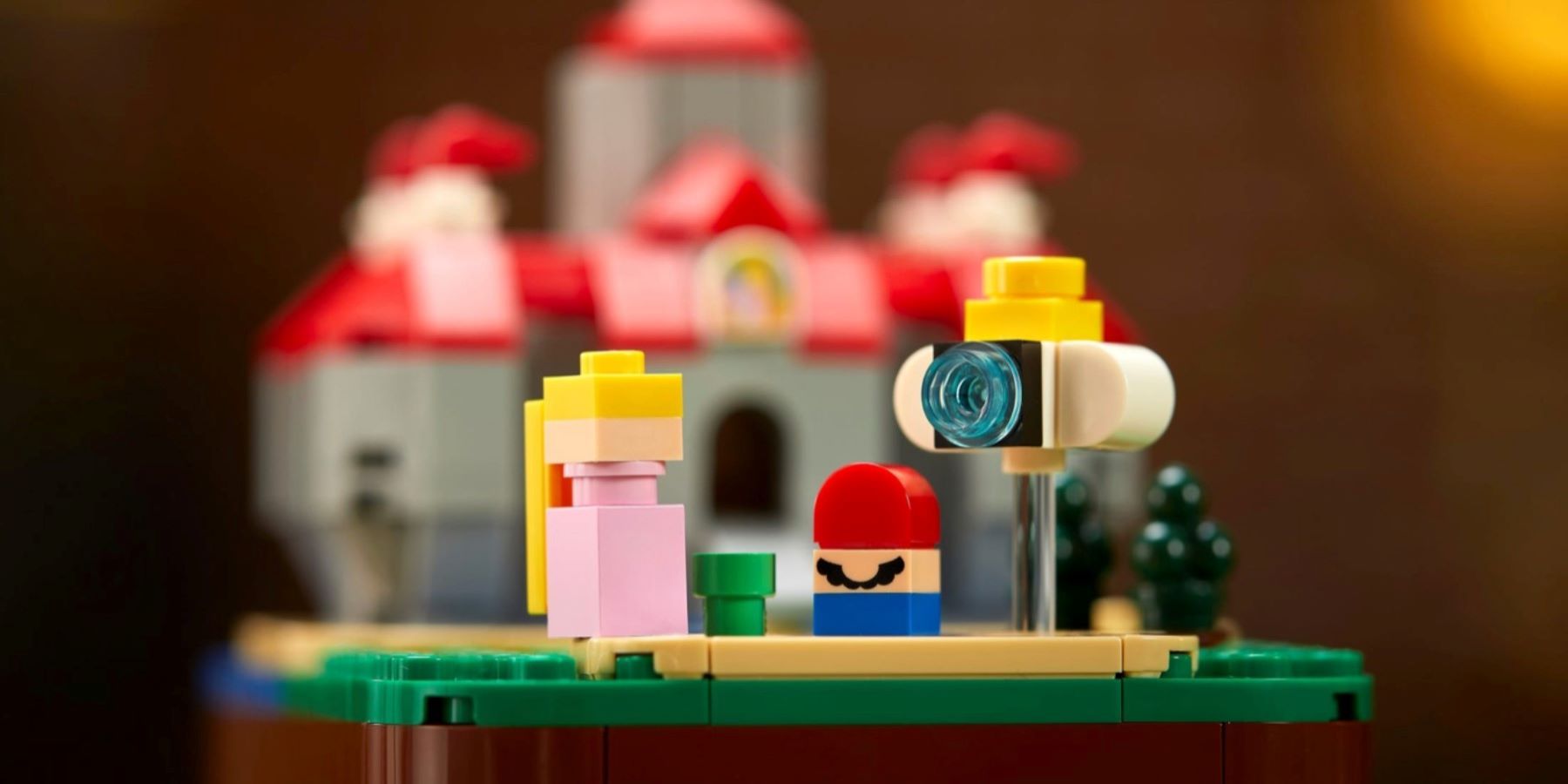 LEGO microfigures of Mario, Princess Peach, and a Lakitu in front of Peach's Castle in the Super Mario 64 LEGO set