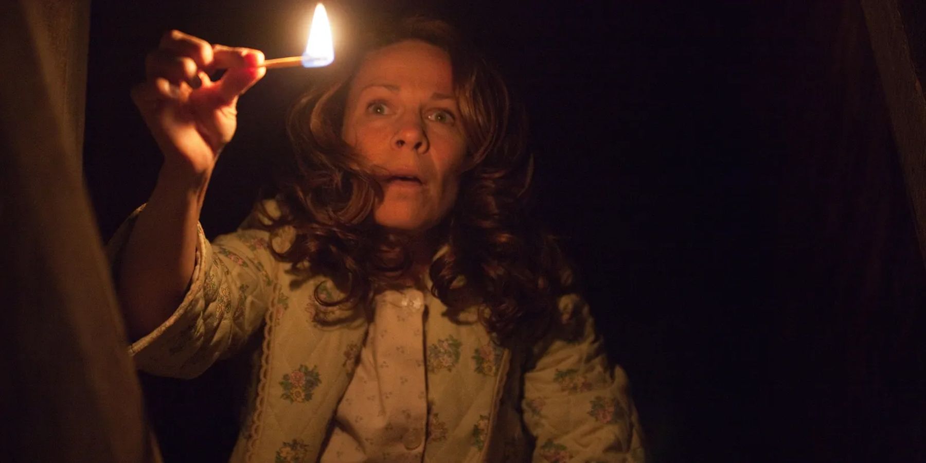 The Conjuring holding a match in a dark space