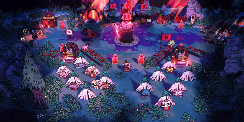 Cult of the Lamb's playable character watches over their flock of cult followers as they sleep with the cult's deity statue in the background.