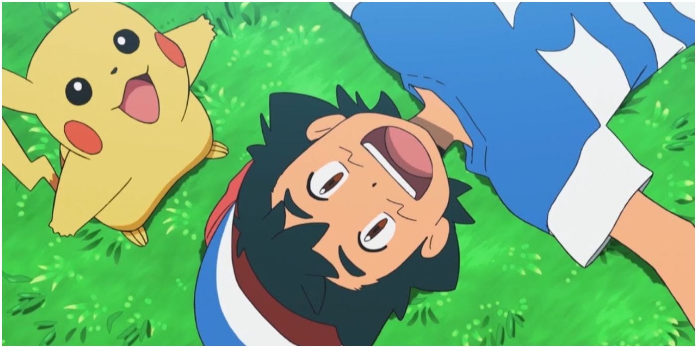 Ash lying on the grass smiling with Pikachu posing happy beside him