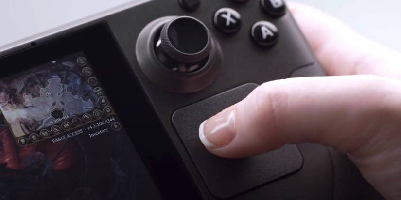 A close up photo of the Steam Deck with someone's thumb on the trackpad.