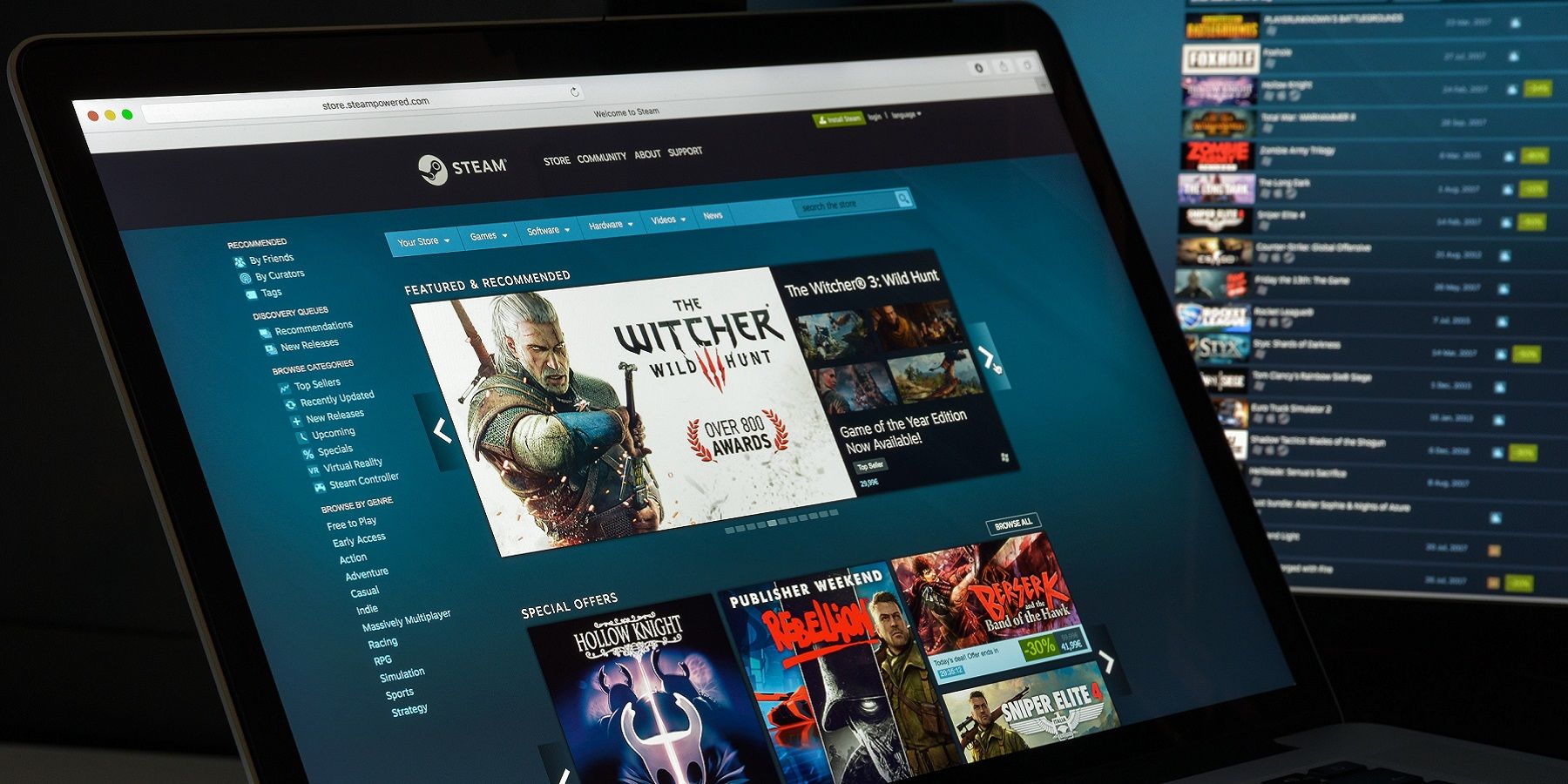 Photo of a laptop with the Steam client on the screen, with another monitor in the background also showing Steam.