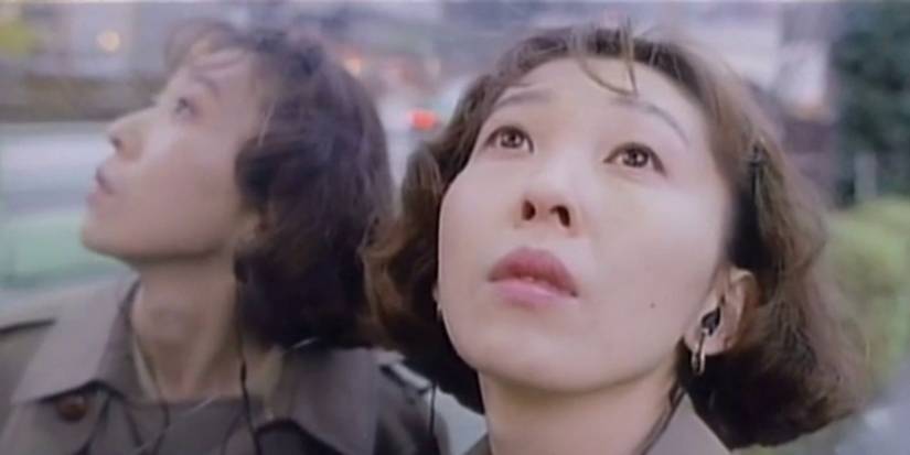 A woman and her reflection gaze upwards in Kirie Eleison