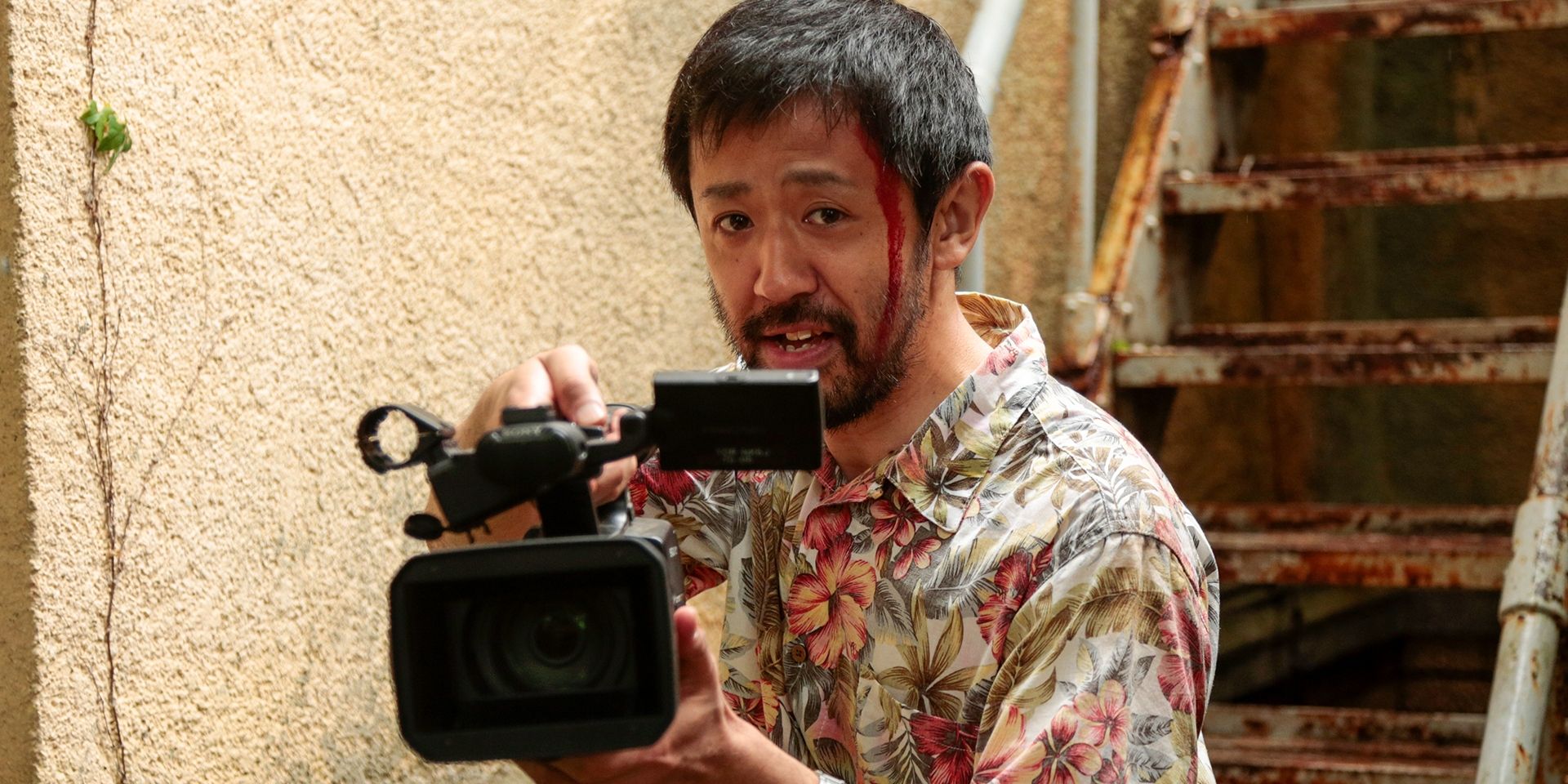 The director films while standing next to a stairway in a scene from 'One Cut of the Dead'