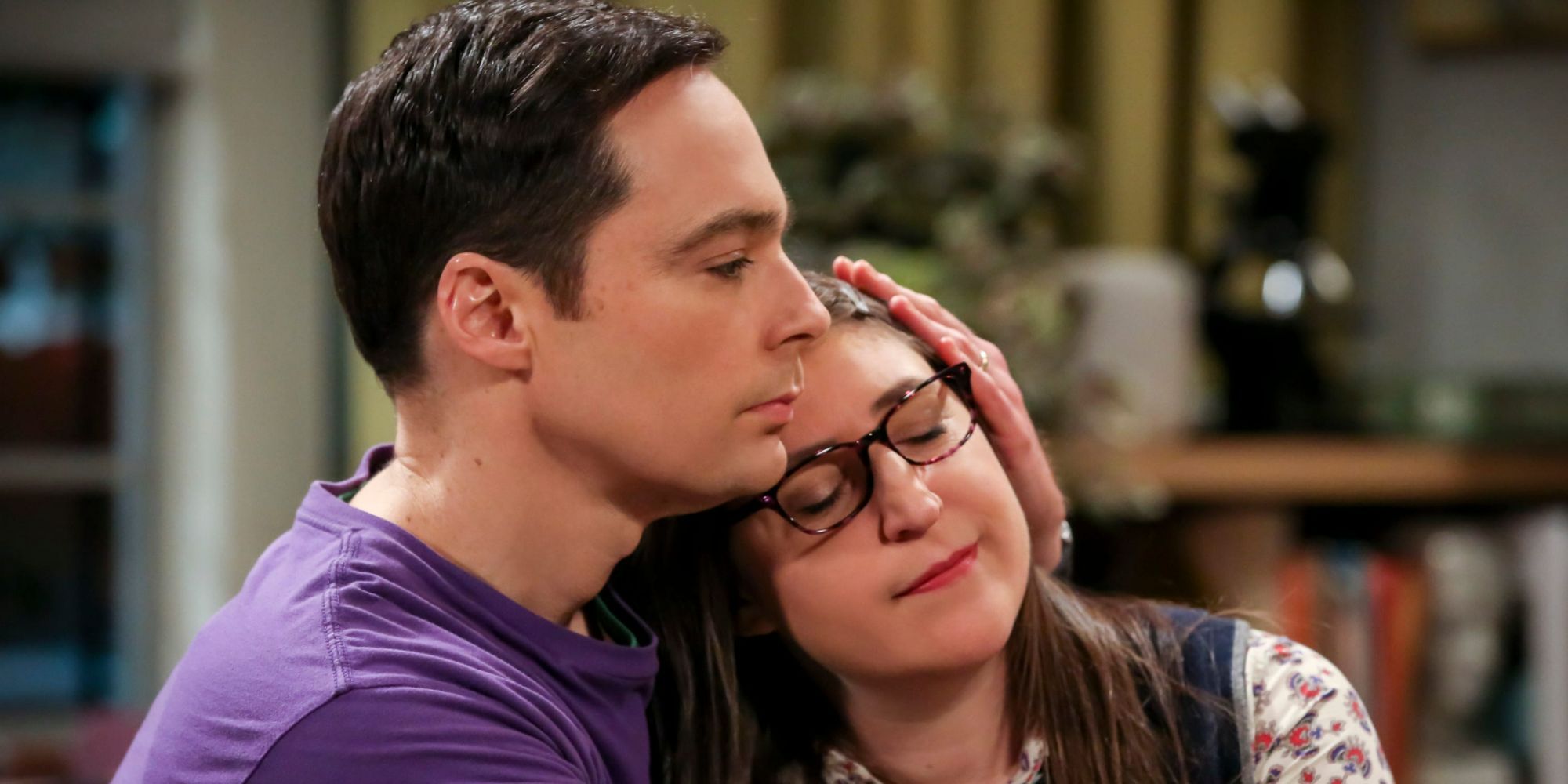 Sheldon cuddles with Amy on the couch in The Big Bang Theory