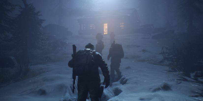 Characters from The Day Before walk up a snow hill towards a cabin.