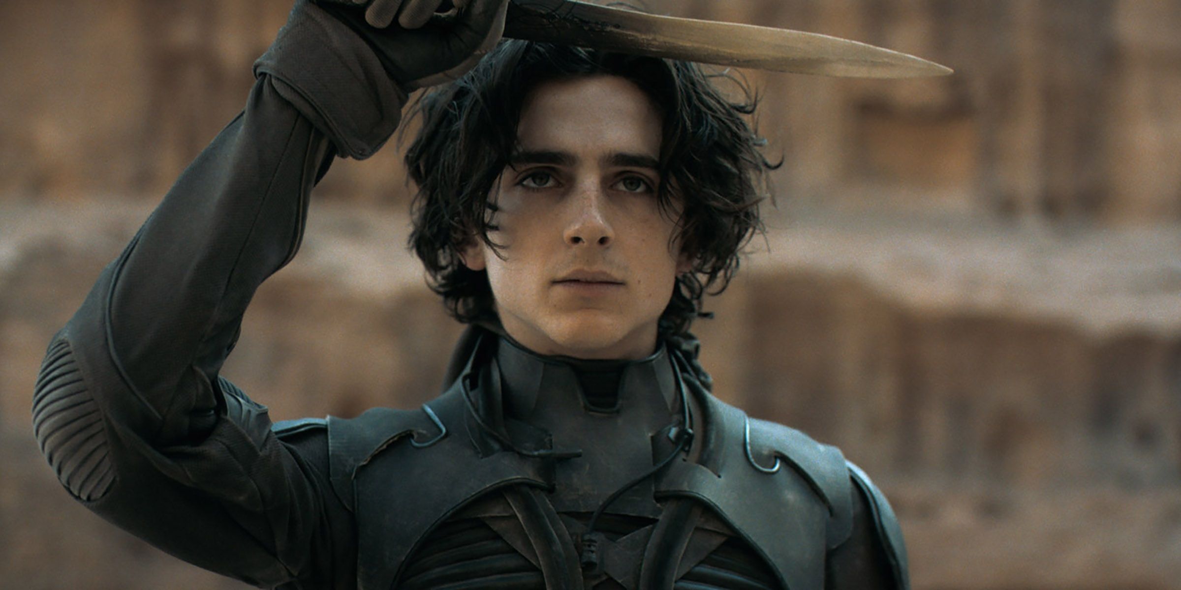 Timothee Chalamet as Paul holding a blade in Dune