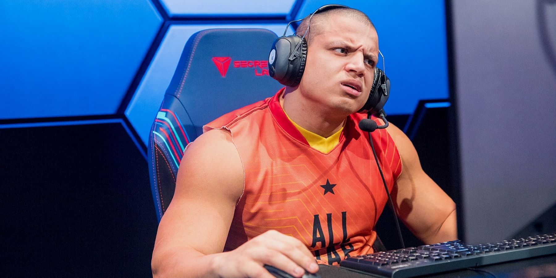 Tyler1 wearing a headset and squinting at a computer screen