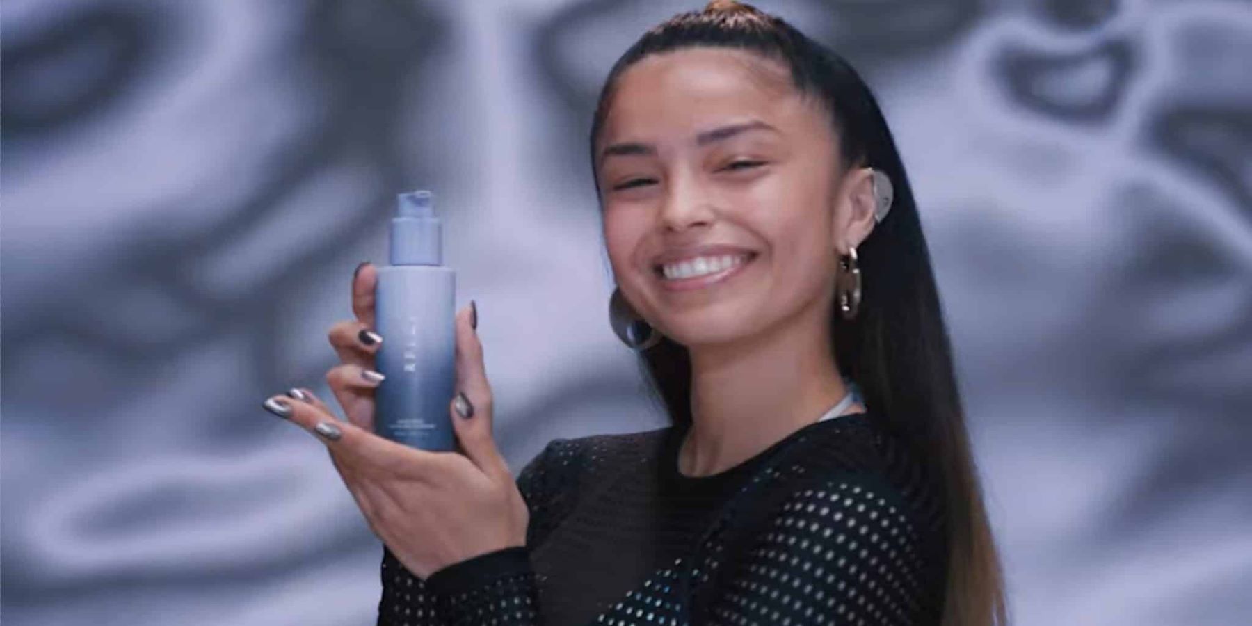 YouTube streamer Valkyrae holding up a bottle of RFLCT skin care product in a promotional image