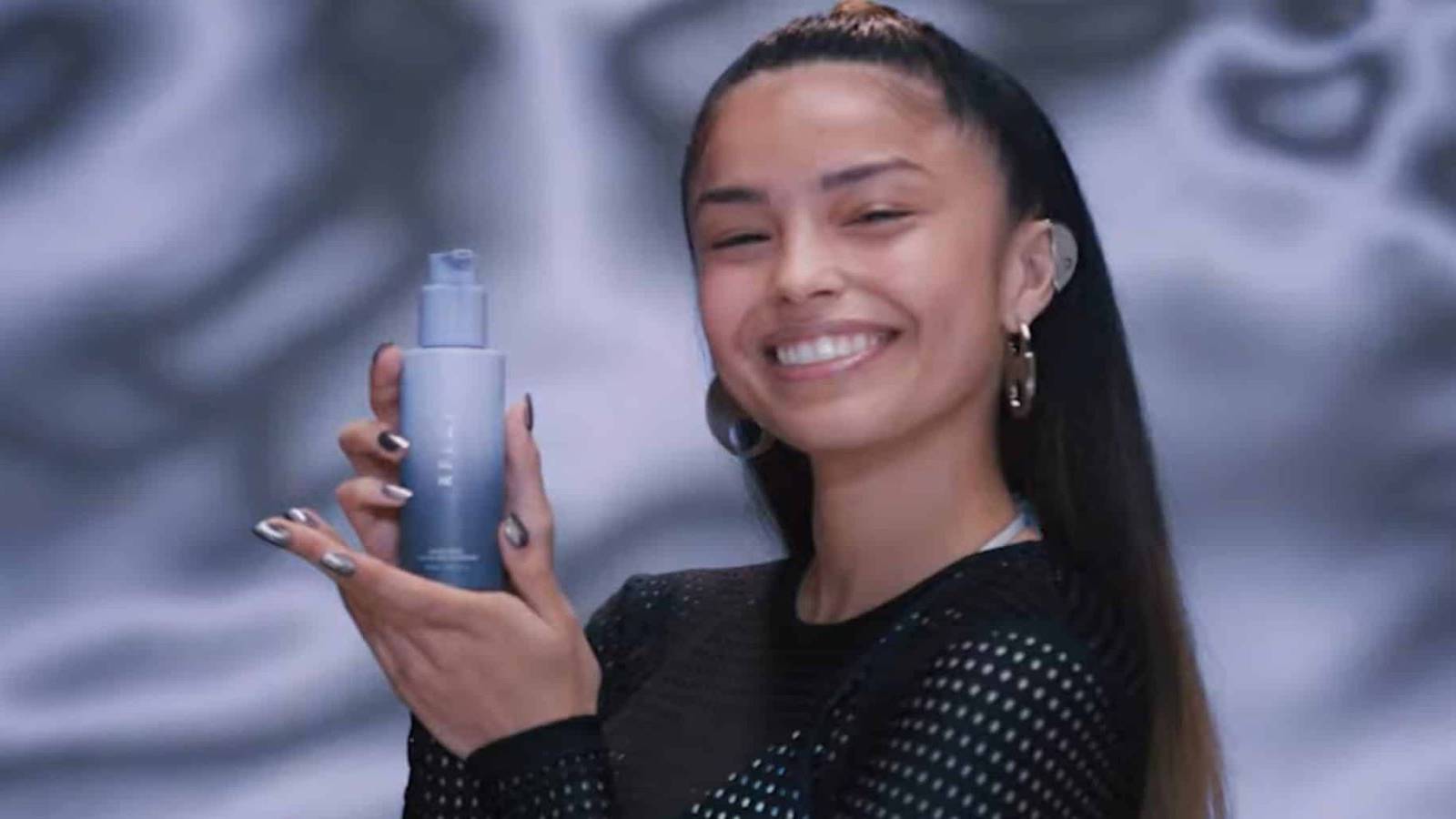 YouTube streamer Valkyrae holding up a bottle of RFLCT skin care product in a promotional image