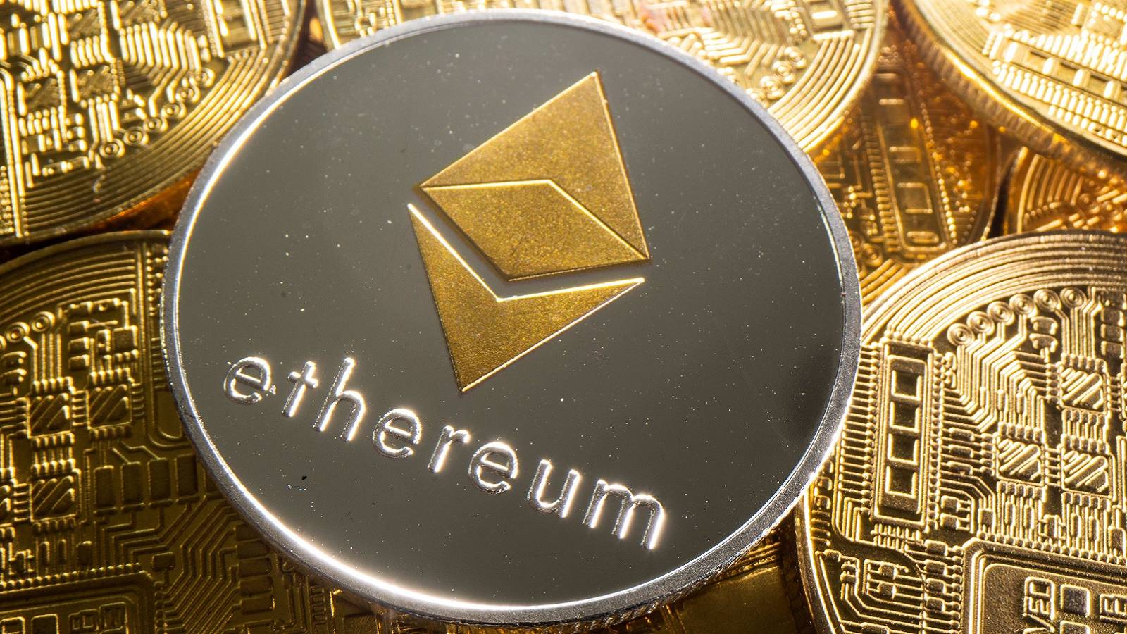 An image showing a silver Ethereum coin on top of a pile of gold coins.