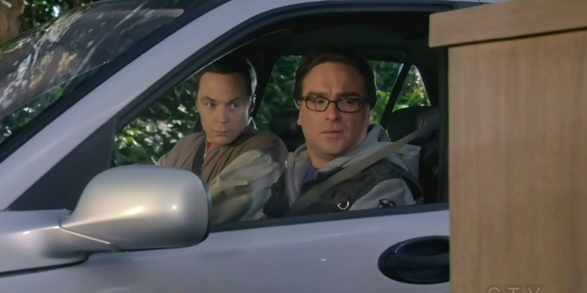 Sheldon sits in the passenger's seat while Leonard drives in The Big Bang Theory