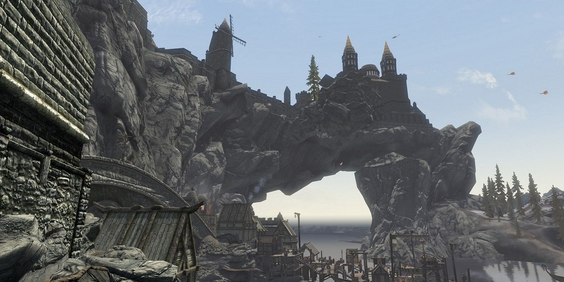 A screenshot from Skyrim outside the city of Solitude showing the arched cape that goes over the river.