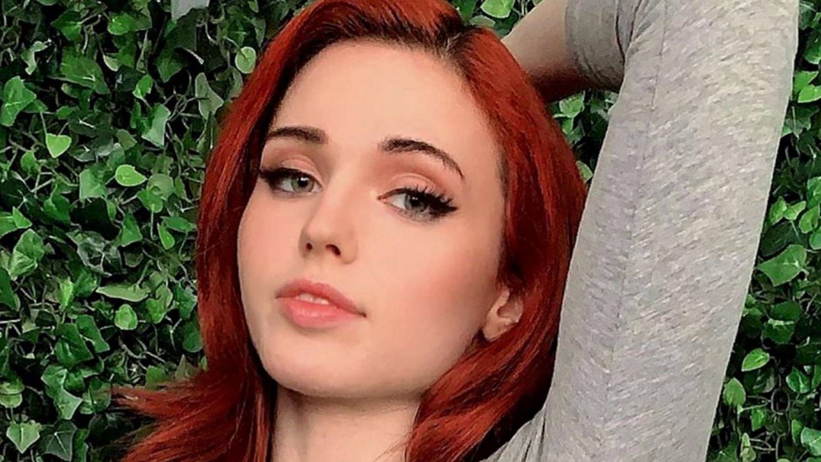 Twitch streamer Amouranth posing in front of a hedge
