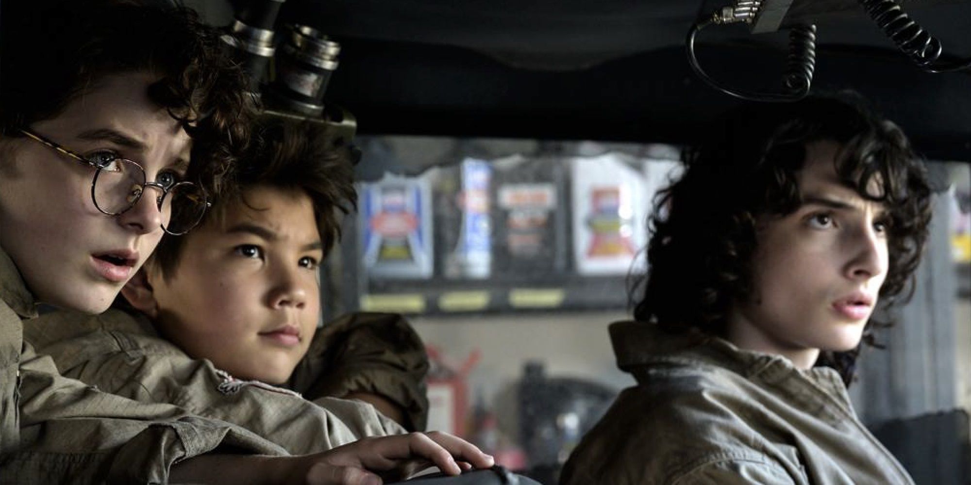 Finn Wolfhard, Logan Kim, and Mckenna Grace in Ecto-1 in Ghostbusters Afterlife
