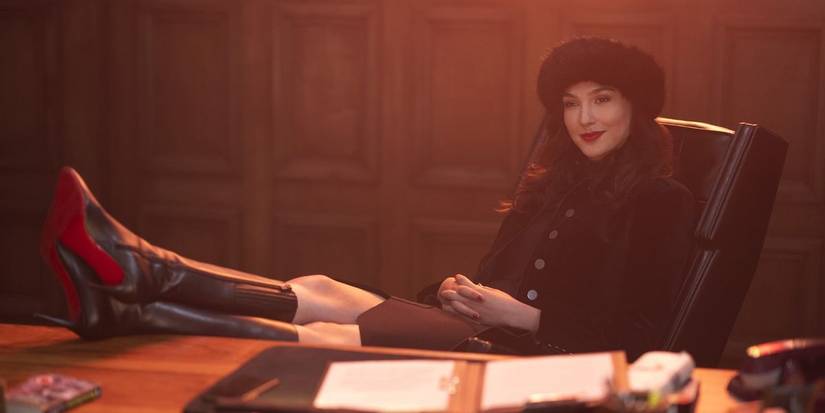 Gal Gadot sitting behind a desk in Netflix's Red Notice