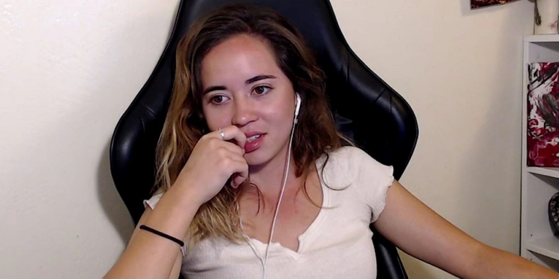 Twitch streamer Maya wearing earbuds and looking concerned during a stream