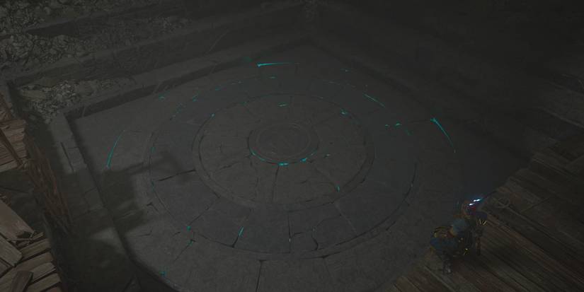 A large, faintly glowing stone slab in the floor surrounded by wooden walkways