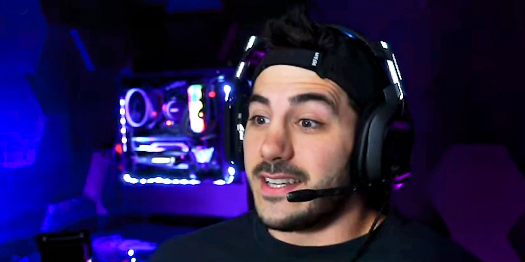 NICKMERCS wearing a headset and speaking to his Twitch stream with LED lights in the background