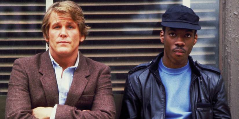 Nick Nolte and Eddie Murphy standing against a wall in 48 Hrs
