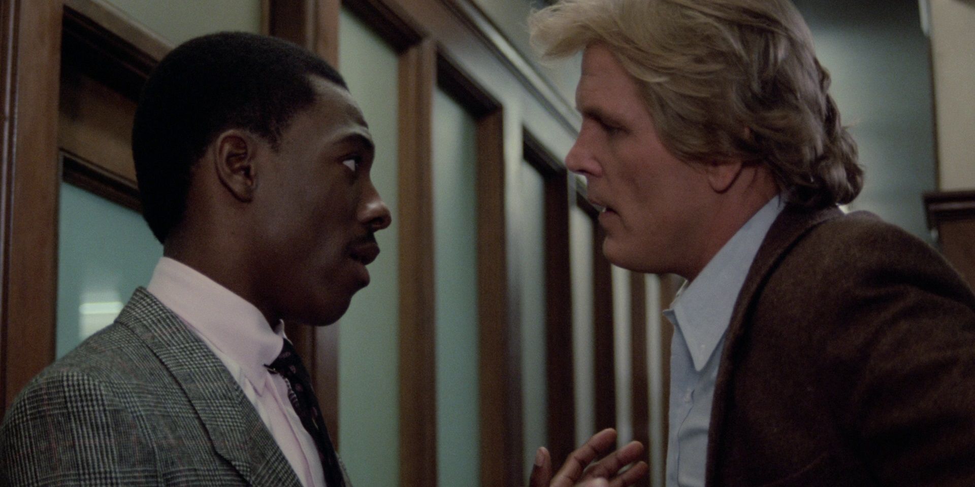 Nick Nolte and Eddie Murphy talking in a hallway in 48 Hrs