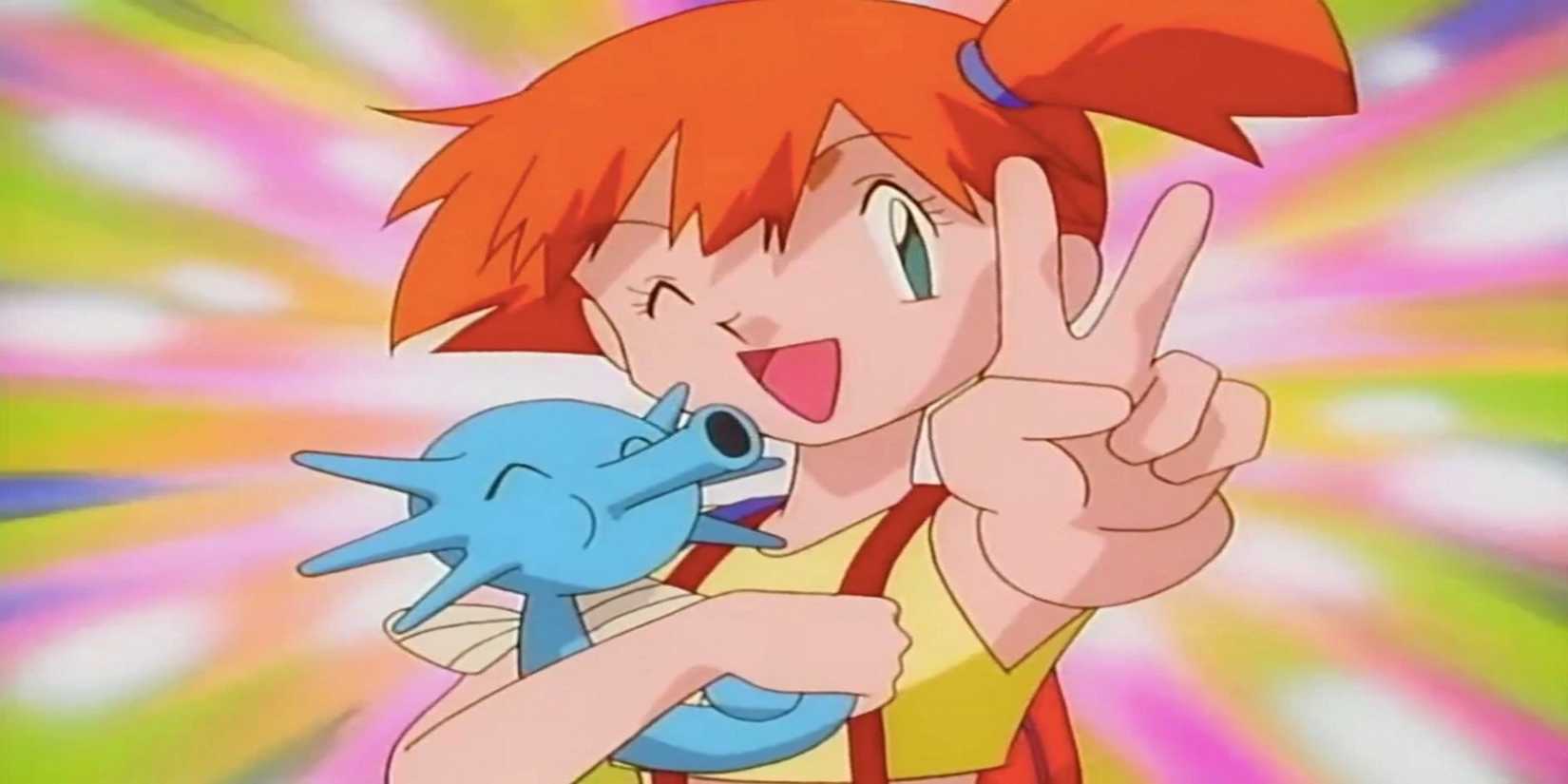 Misty smiles and throws up a peace sign while holding a Horsea in Pokemon.