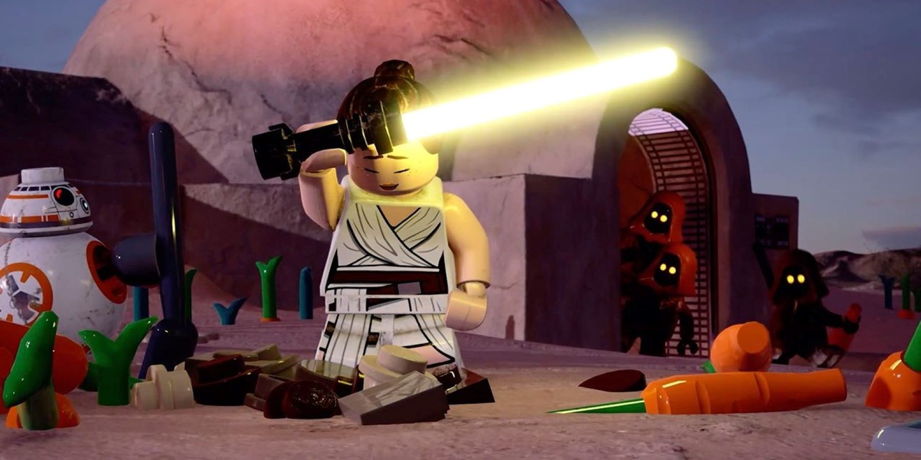 Rey holding a yellow lightsaber and standing in front of a hut on Tatooine while surrounded by BB-8, Jawas, and carrots in LEGO Star Wars: The Skywalker Saga