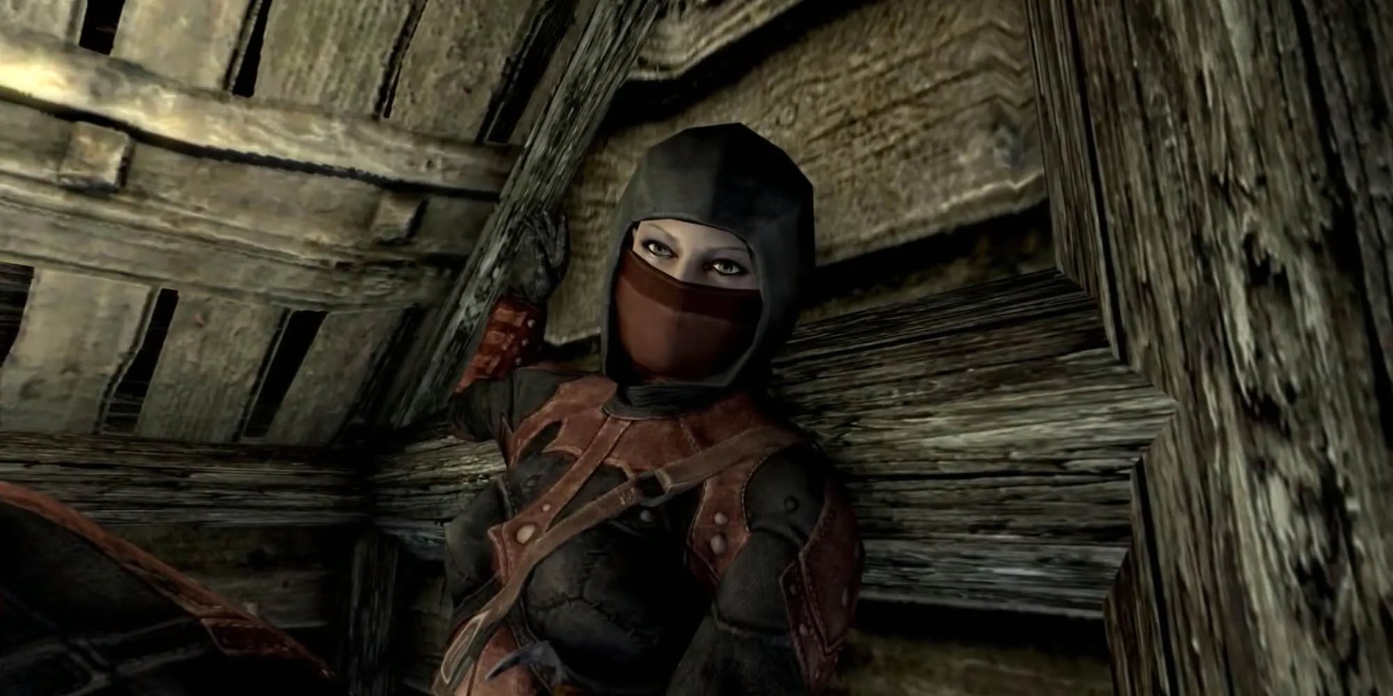 Astrid from the Dark Brotherhood sitting in a log cabin in The Elder Scrolls V: Skyrim