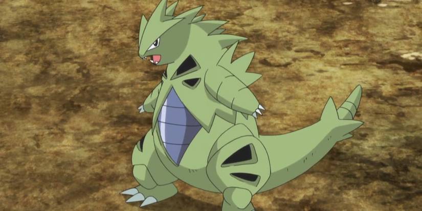 Pokemon Tyranitar standing against rocky background