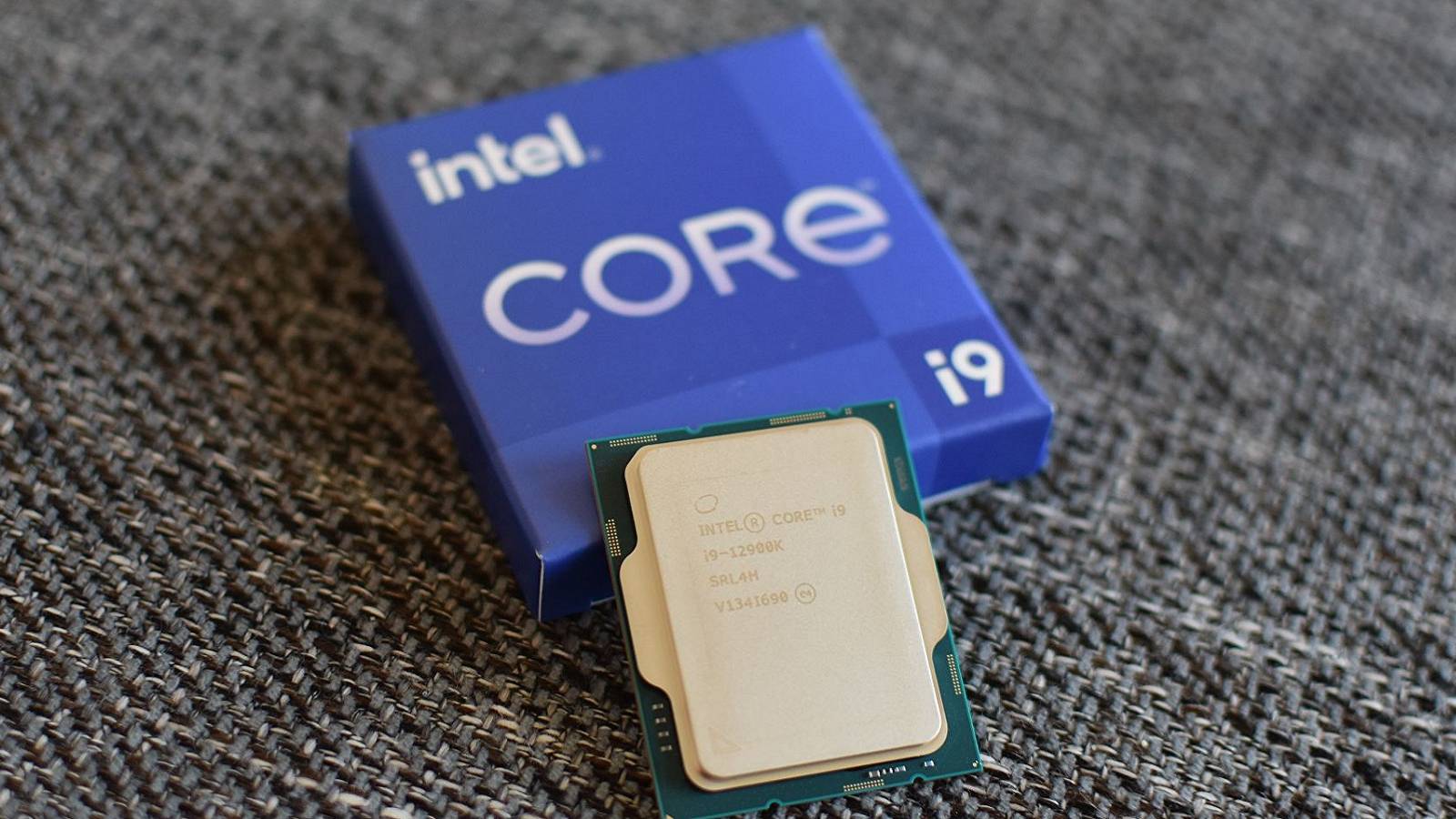 A photo of the Intel i9-12900k processor leaning againts its display box.