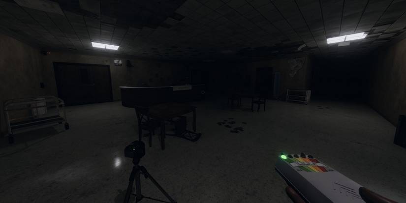 Screenshot from Phasmophobia showing the player holding an EMF reader.